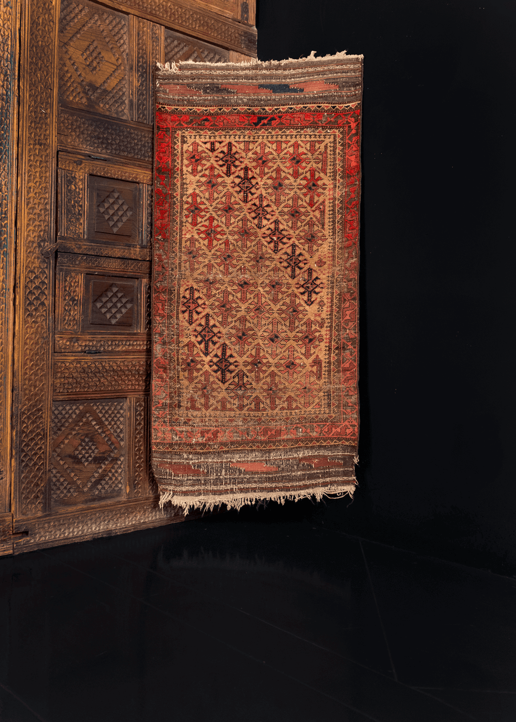 Antique Baluch rug with a hooked-diamond pattern on a camel ground, with 's' main border and kilim skirt ends. Main colors are reds, browns, and blues.