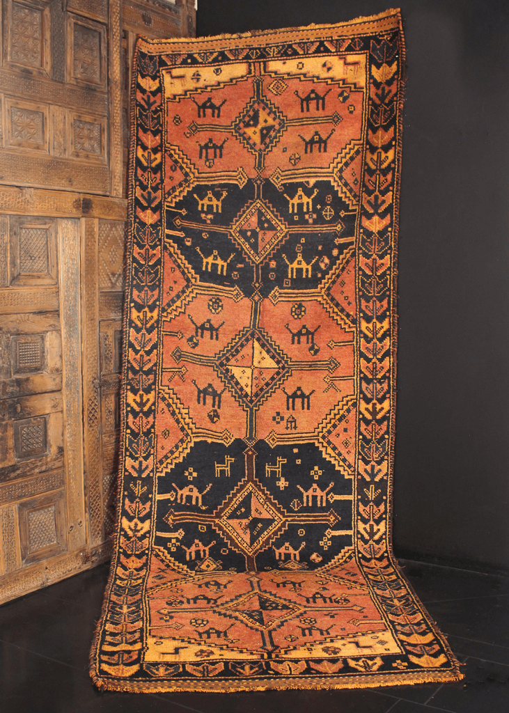 Mid century Persian Shiraz runner with warm color palette of orange, yellow and black. Five medallions containing camels, rosettes and various charms. 