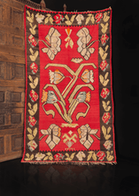 Bessarabian kilim from the second quarter of 20th century. Large scale geometric composition of flowers. Central flower motif on a bright red field framed by dark brown border with roses and leaves. 