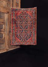Hamadan rug from the 1930s featuring a repeating geometric pattern on a deep blue indigo field, with additional geometric or floral shapes in blues and reds