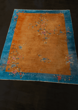 Chinese Deco rug with rust brown field and cobalt blue border with floral sprays and meanders arranged in freeform manner throughout the rug. In very good condition, signs of wear consistent with age