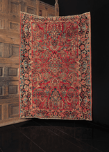 antique sarouk rug with curvilinear floral design on a raspberry red field and unique borders