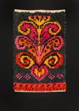 Mid century Rya rug handwoven in Sweden. Bright scroll like symbol in yellow, pink and orange atop forest green field. 