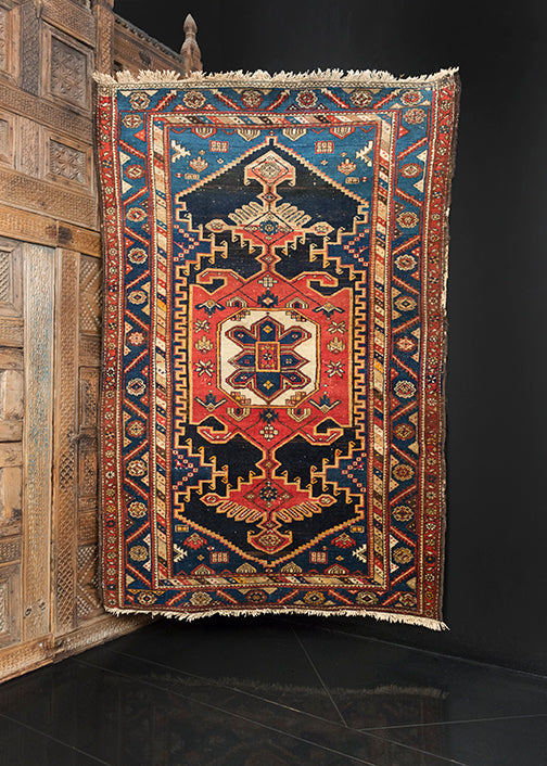 Northwest Persian rug handwoven first quarter 20th century. Mix of indigo, black, ivory and peach tones. Geometric medallion with multiple layers spanning the rug. 
