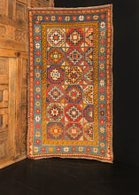 Moghan Kazak rug handwoven during late 19th century in the Caucasus. Vibrant palette that highlight multiple "memling gul" medallions. Pink, bright blue and orange. 
