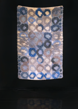 Rya shag rug handwoven in Sweden during middle of 20th century. Pattern of undulating circles in shades of blue and ray atop a backdrop of alternating ivory and blue squares. 