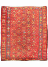 Serbian Pirot kilim featuring an all-over design of shrub-like motifs in yellow, brown, purple, and ivory of vibrant red ground. It is framed by an inner border of geometric rosettes on a brown ground. A wide outer border with the same vibrant red ground as the field features abstracted forms reminiscent of the national symbol of Serbia - the double-headed eagle.