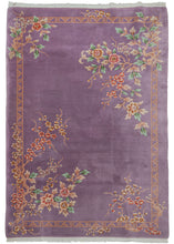 Mid century Chinese deco rug featuring a cheerful purple field. The design is open and borderless, with unique but reciprocating patterning in each corner. Each corner consists of bunches of blossoms in pinks, blues, oranges and greens. The whole is framed by an interlocking "LALALA" border.