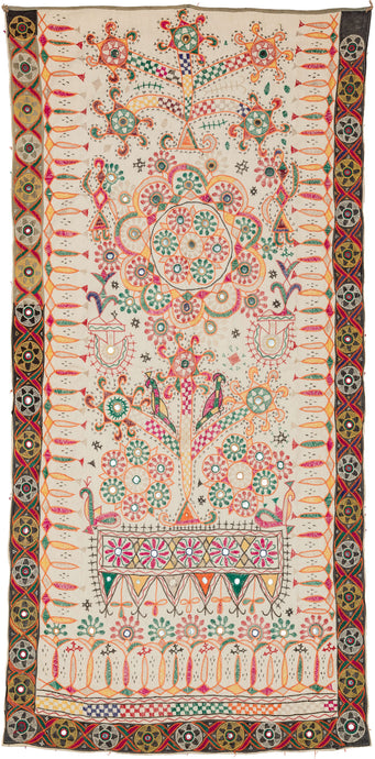 Mid century Kutch Dharaniya Embroidery featuring a free-hand design of trees, birds, and rosettes, embroidered in a rainbow of colors alongside lovely mirror-work. We find yellows, oranges, greens, and pinks, on a soft ivory ground. The border is black with mirror-work embroidery resembling suns.