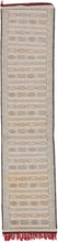 Midcentury Hanbel runner featuring crafted of cotton wefts on a cotton foundation and features subtle details in silk throughout. Horizontal rows of many different geometric shapes span the length of the rug. Black, white, soft yellow, and dashes of light blue silk make up the palette with long red fringes providing a colorful detail.