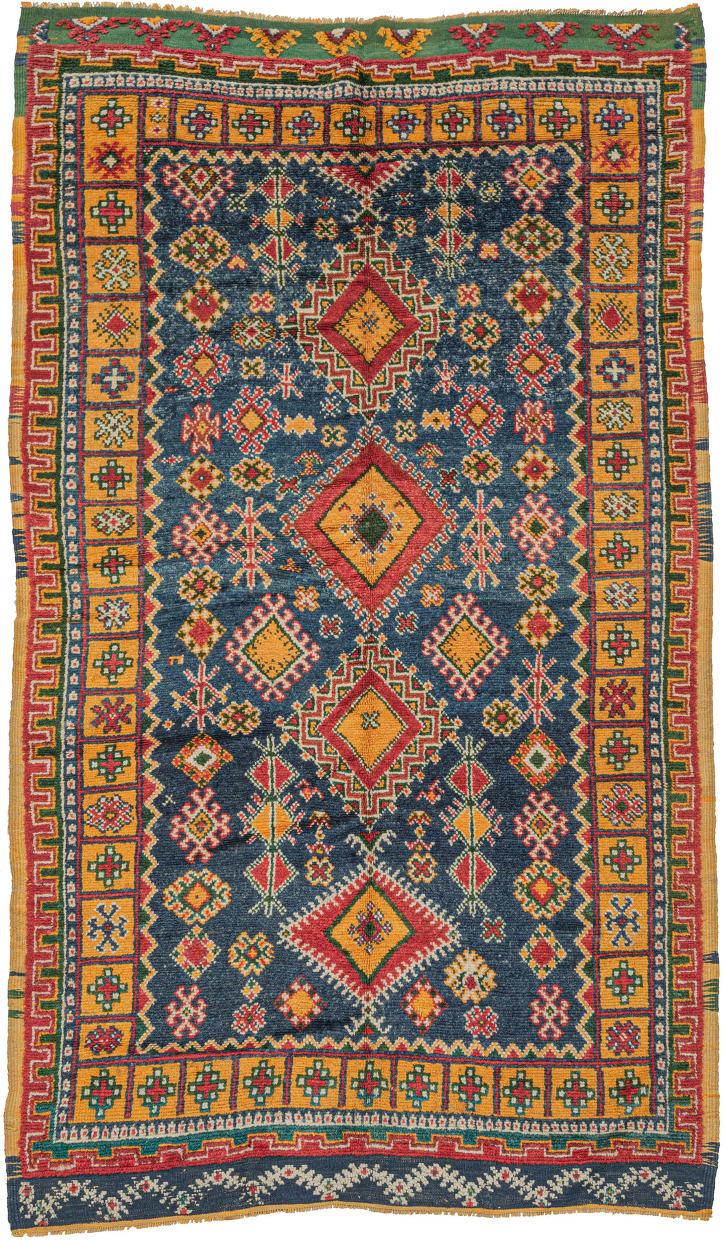 Midcentury Moroccan Taznakt kelleghi area rug featuring a field filled with various protection symbols and a central axis of powerful diamonds on rich Mediterranean blue ground. The spectacular blue contrasts perfectly with rich red, saffron yellow, and emerald green with ivory accents. Many of the protection symbols found in the field can be found in the wonderful main compartmentalized main border.