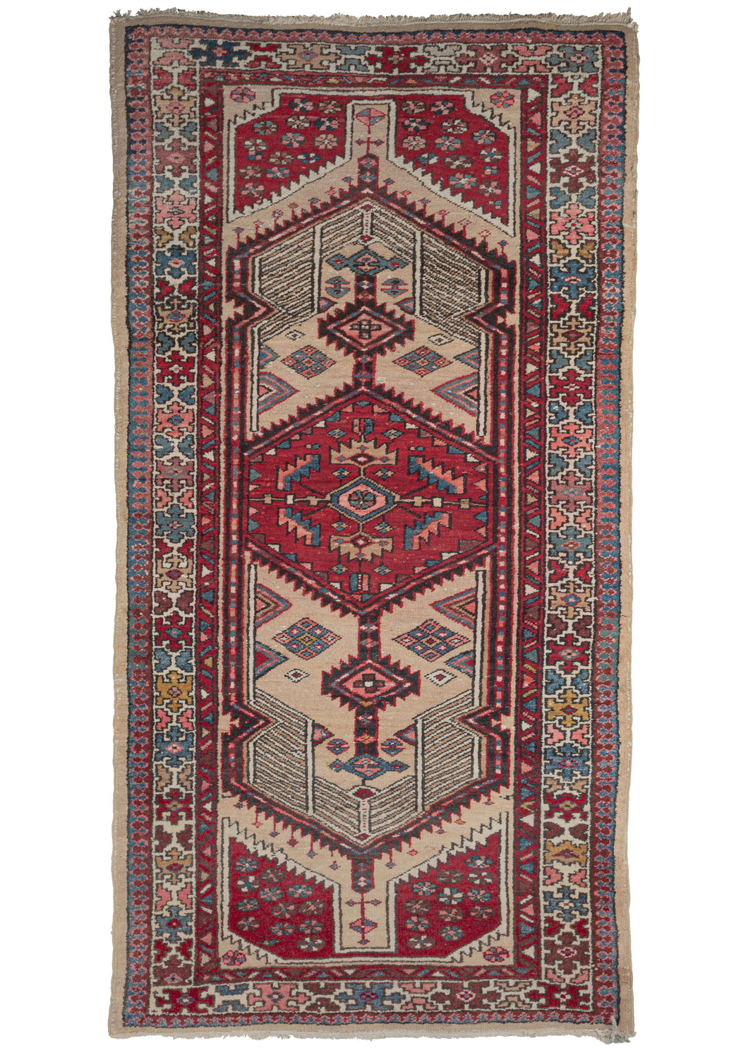 This Vintage Serab Rug features a sandy camel ground which lends the soft backdrop for saturated blues, reds, pinks, and yellows. The ivory in both the latticework and ground of the main border work to brighten the whole.
