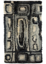 Mid century Swedish Ryya featuring a geometric design in black, white, and grey. Overall it has an abstract grid like design, filled with asymmetric rectangles, ovals and squares. The geometric design mixed with the long shaggy pile, gives a very modern feel. 