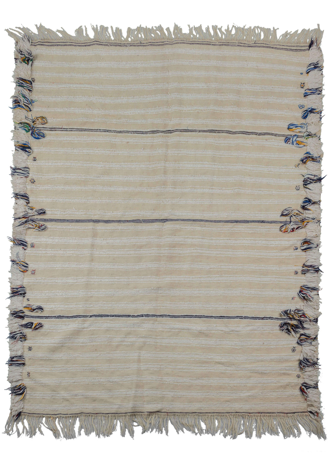 Moroccan wedding blanket that features cream tone on tone horizontal bands which have a perimeter of plush bands of thick pile in white with stray pops of blue, green, yellow and black. One the reverse it features the same horizontal bands, but the perimeter has blocks flatwoven black and white geometric patterning.