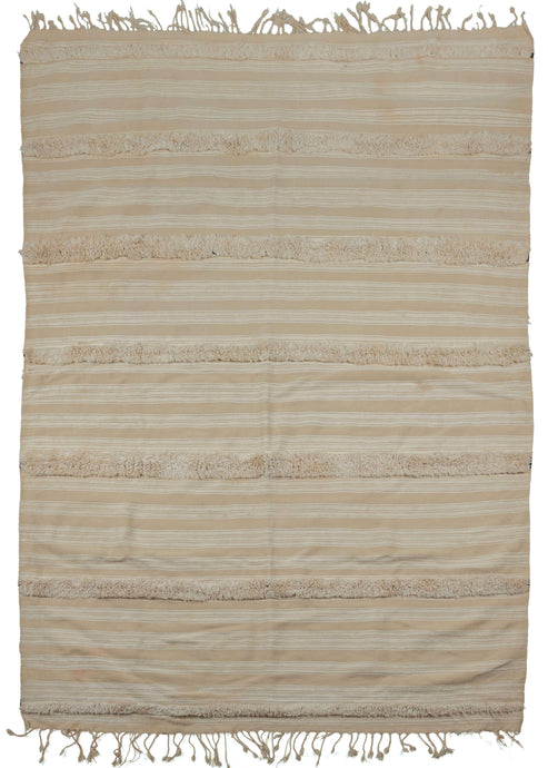 Moroccan wedding blanket that features cream tone on tone horizontal bands which are occasionally superseded by plush bands of thick pile. On the reverse the same horizontal bands are broken up by patterned geometric bands in black and white.
