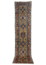 NW Persian Karadja runner featuring a central latch-hooked central lozenge flanked by three geometric stars on each side. The stars alternate in soft blue and bright white which flows harmoniously on the equally uncommon gold backdrop. Deeper indigo blues and soft pinks, chocolate, and rust complete the pleasing palette.
