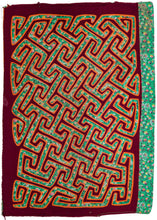 Panamanian handquilted applique Kuna Mola cloth featuring vibrant tones of burgundy, orange atop soft green with pinks, yellow and white. The pattern is very graphic features interslocking latchhooked motifs in maze like formation. The first layer used was a printed cloth with paisley and flowers which provides the base of subsequent layers and which adds a dizzying quality to the latch hooked figures. 