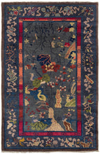 Chinese small deco rug featuring a water scene of various scholar stones, birds, and vegetation. The varied blues, greens, oranges, reds, and yellow really stand out against a calming periwinkle ground. Framed by an energetic inner border of varied blocks of red, oranges, and pink and well-spaced interlocking circles, the main border features the eight auspicious symbols of Buddhism on a darker shade of periwinkle.