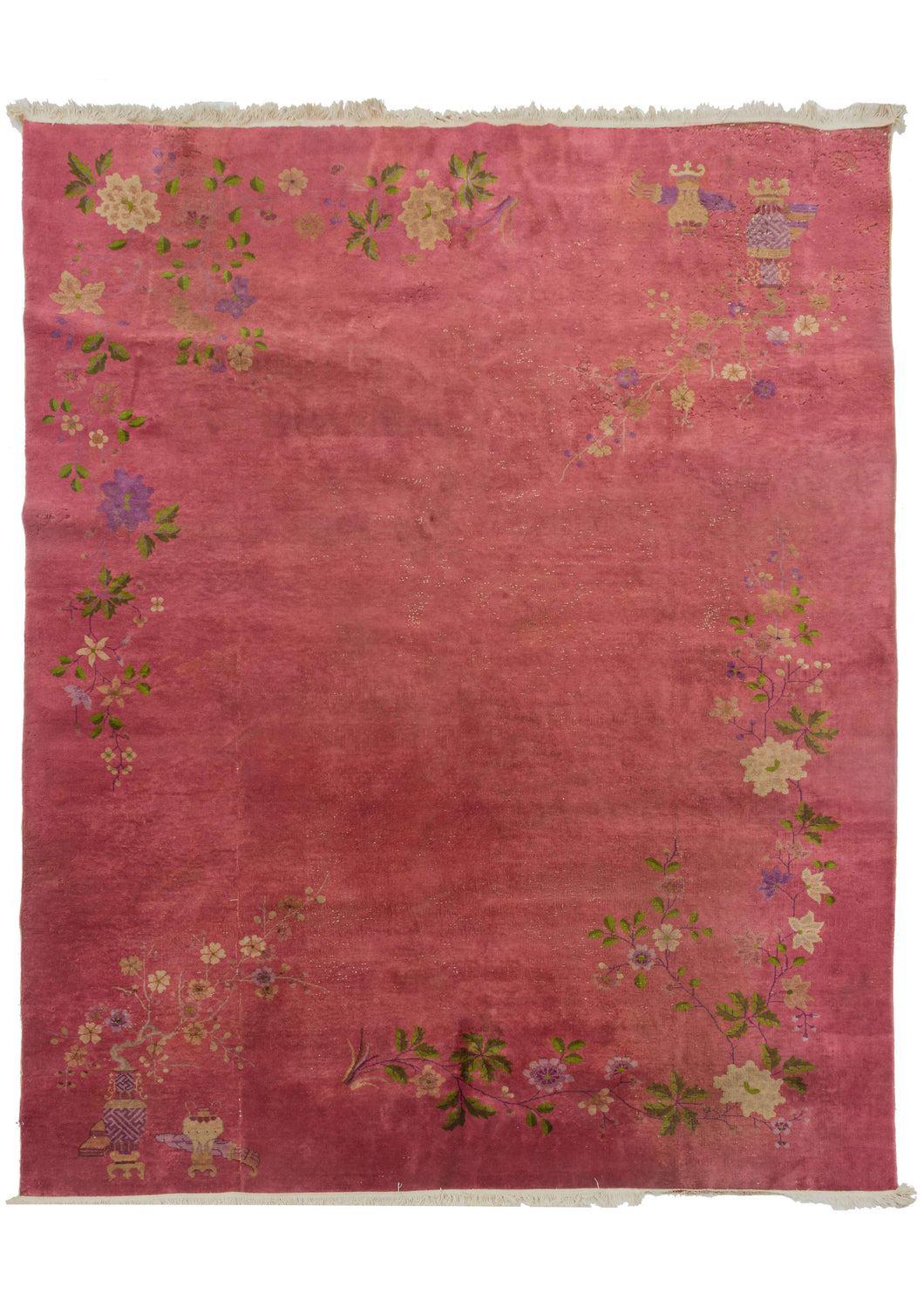 This Deco rug features a sparse and delicate floral design on an immense coral field. The design is open and borderless with a variety of flowers growing on vines as well as out of vases. The accenting palette is composed of greens, pinks, browns and golden yellows. 