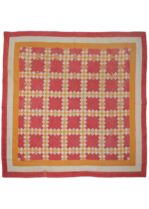 This Vintage North American Quilt features a grid composed of yellow and white diamonds on a red ground. The grid is framed by solid yellow, white and red borders. The whole quilt has been stitched together in a pattern of concentric diamonds adding another subtle layer of interest.