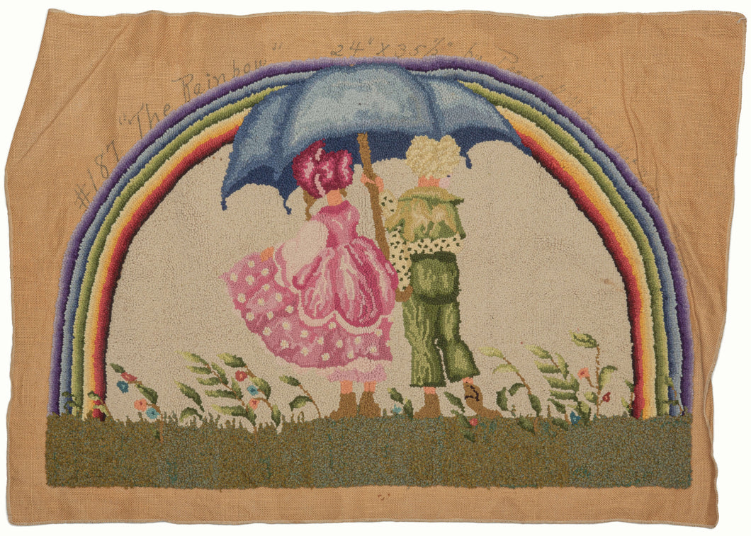 Signed hook rug featuring two childlike figures in a pastoral setting under a rainbow. The girl is wearing a pink shepherdess-like outfit with hoop skirt, and the boy is wearing a green suit. They are both standing underneath a blue umbrella. They are standing in a field with wind-blown grass and flowers, with a rainbow in the sky above them. 