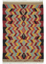 Signed NW Persian Bidjar kilim featuring a geometric design radiating out from the central diamond column. Within each diamond is a rooster, a calice flower, or a tree. The colors utilized are light blue, yellow, peach, red, tan, and black. The tan skirt border has an inscription on the bottom which reads: "Kilim Mosheri P" - the weaver's signature and the style of rug. It's unclear what the number represents, perhaps some kind of date or production number. 