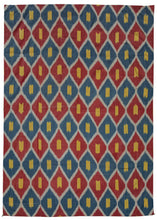 Silk Uzbek handwoven ikat textile featuring a repeating interlocking diamond motif in blue, red, and yellow with a white outline. The back is a brightly colored paisley print on synthetic fabric. 