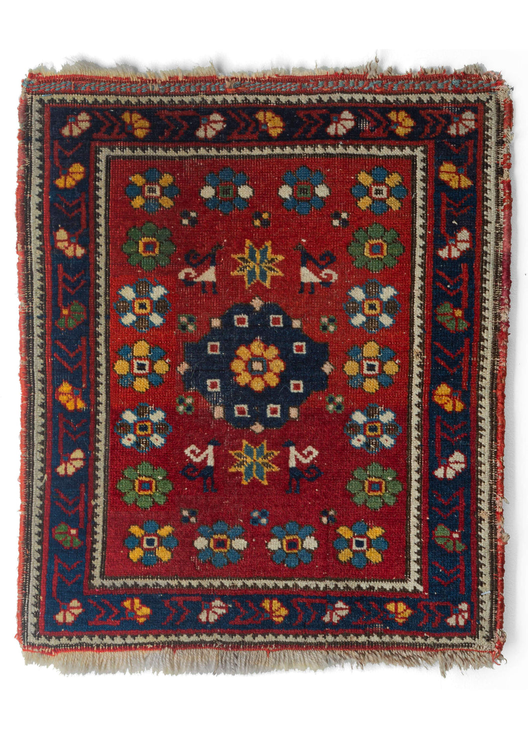 Small brightly colored Caucasian Daghestan rug with primary colored flowers very pop