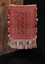 Vintage Turkmen trapping, handwoven in C Asia.   This trapping features a classic Turkmen color palette and design, with a small main field of composed of Turkmen güls, framed by six small borders all featuring classic geometric designs. The color palette is composed of earthy reds, oranges, browns, and deep blues. In excellent condition, with no signs of wear. Low pile, original fringe and tassels still intact, with a sturdy handle. 