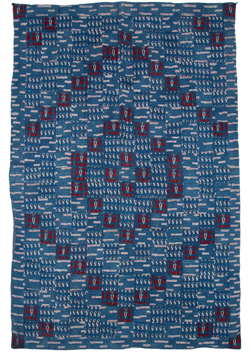 Vintage Indian quilted blockprint quilt featuring a celebration of indigo. Blue is the main color, with red, black, and white providing details. It uses three different block-printed fabrics, one of which uses writing to great effect, while the other two are geometric designs. The fabrics are cut and pieced together in a diamond design. The back is lined with a striped whole cloth.