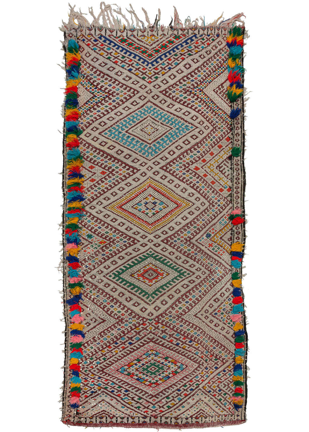 This Vintage Middle Atlas Zemmour Runner features a column of flatwoven concentric diamonds in turquoise, yellow, green, and red that pop against a white cotton field. The same tones are woven in fluffy rows of pile along the edges adding fun and excitement. It is crafted of wool and cotton wefts on a cotton foundation with dangling metal sequins woven throughout. 