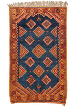 This Vintage Moroccan Rug features a variety of larger concentric and smaller latch hooked diamonds on a midnight blue ground. Diagonally striped cornices add movement and power to an otherwise classic composition. Framed by a nicely contrasting saffron border with accents of red, brown, ivory, blue, and green. 