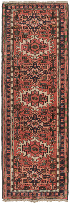 Vintage Nw Karaja small runner featuring a pattern of alternating geometric shapes and hooked lozenges on a soft red ground. Blues, green, purple, gold, pink, and ivory provide a well-balanced palette. In a rare narrow and short runner format.