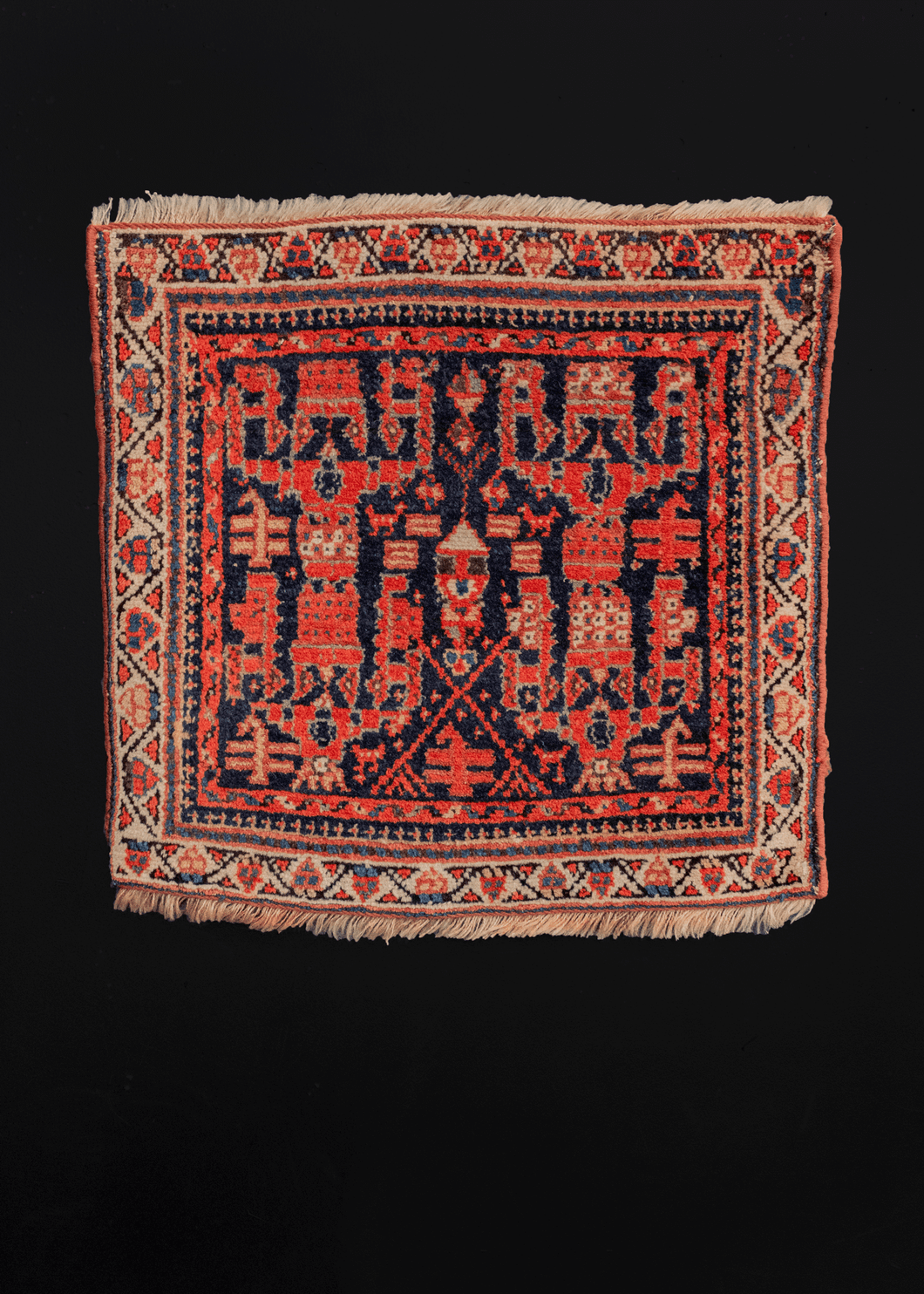 Northwest rug handwoven during the second quarter of the 20th century.  This quirky rug features a very unique and unusual geometric design in bright oranges and reds on a deep indigo field. The ivory border frames the design, giving the rug a very painterly quality. Would look fantastic as a wall hanging!  In very good condition, signs of wear consistent with age.
