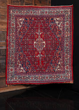 Mid-century Hamadan rug with central medallion in a red based color palette. In excellent condition, signs of wear consistent with age. 