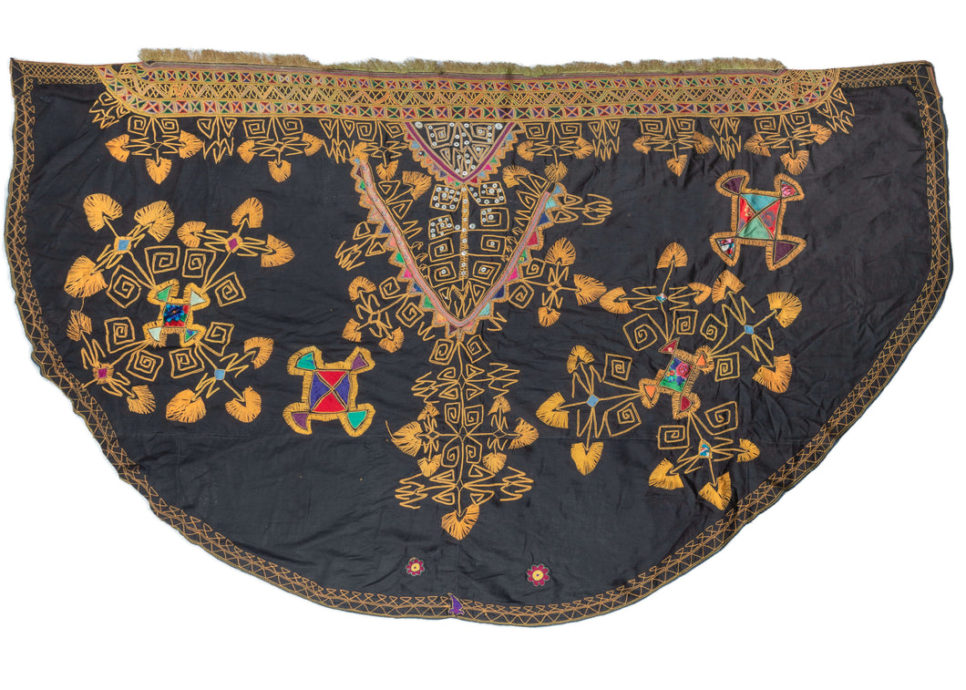 This half-moon shaped textile is composed of multicolored cotton embroidery, with some funky details provided by white buttons in the center. Appliqued shapes provide more color and visual interest. 