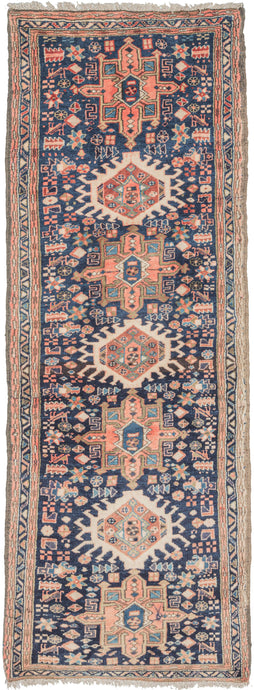 Vintage blue Karaja runner featuring a pattern of alternating geometric shapes and hooked lozenges on a rare and enticing blue ground. Maybe one out of a hundred of this type utilize a blue ground and the blue and ivory are combined to spectacular effect. Green, gold, and pink add additional accents. In a rare narrow and short runner format.