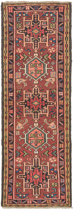 Vintage small Karaja runner featuring a pattern of alternating geometric shapes and hooked lozenges on a red ground. Blues, green, charcoal, gold, pink, and ivory provide a well-balanced palette. In a rare narrow and short runner format.