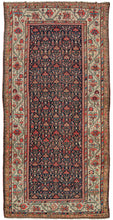 This Persian Malayer Kelleghi features a wonderful all-over flower-filled lattice field. The design is rendered in soft blues, red, coral, ivory, gold, and sea foam on a navy ground. It is framed by a wide border of scrolling vine work and big blossoming palmettes on anivory ground. The ivory brightens the whole composition and softens nearby tones including a delicate lilac only present in the borders.