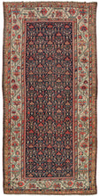 This Persian Malayer Kelleghi features a wonderful all-over flower-filled lattice field. The design is rendered in soft blues, red, coral, ivory, gold, and sea foam on a navy ground. It is framed by a wide border of scrolling vine work and big blossoming palmettes on anivory ground. The ivory brightens the whole composition and softens nearby tones including a delicate lilac only present in the borders.