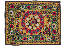 This Vintage Uzbek Suzani features a central mandala with a multilayered arrangement of flowers in blue, white, and bright pink framed by a large outer border of scrolling green vines with flowers in burgundy, pink and white. With little to no space of this textile untouched, the majority of this piece has been meticulously embroidered. 