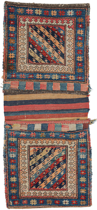 Antique Kurdish Khorjin saddlebag with bag face is low and dense pile, with a flatwoven back in a multicolor striped pattern. The closure is composed of red and blue slit tapestry on the front. The bag-faces feature the traditional Kurdish diagonal design in a rainbow of colors, and two borders. The inner border has a laleh abbasi design while the outer border has a multicolored star design. The variety and depth of color are typical of Kurdish weavings. 