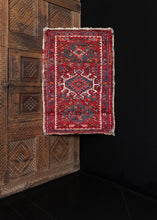 Small Karaja rug handwoven in NW Persia during the second quarter of the 20th century.   The design is composed of three medallions on a deep red field. The rest of the field is filled in with various shapes and geometric designs. The border, which is composed of a geometric floral meander. The color palette includes reds, blues, white, and oranges, while the shapes are outlined in black.   In good condition, signs of wear consistent with age. Low pile, with a sturdy handle. 